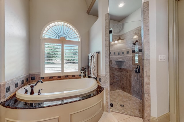 bathroom with a bath, a shower stall, and tile patterned flooring