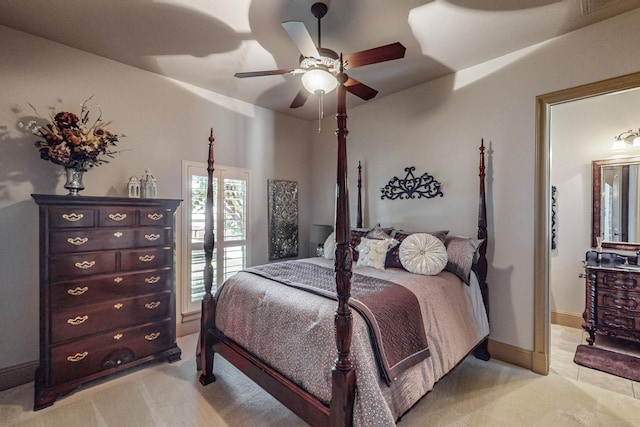 bedroom featuring light carpet, a ceiling fan, ensuite bath, and baseboards