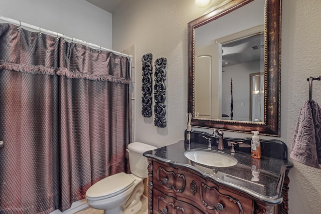 full bathroom with toilet, vanity, a shower with shower curtain, and a textured wall