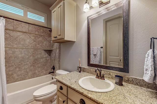 bathroom with vanity, toilet, shower / bathtub combination with curtain, and a textured wall