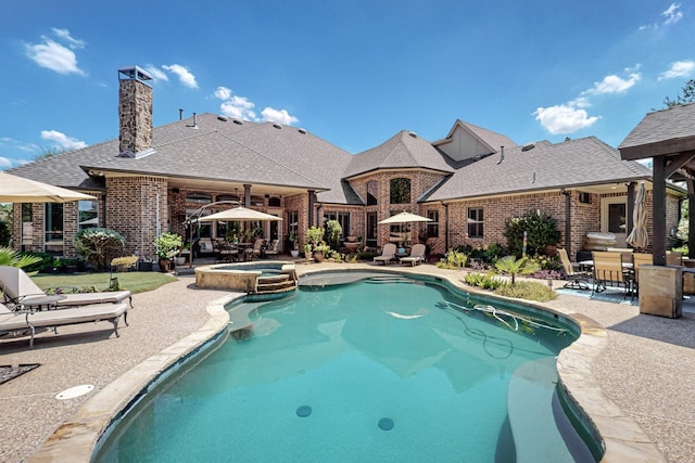 view of swimming pool with a patio area, a pool with connected hot tub, outdoor dining area, and ceiling fan