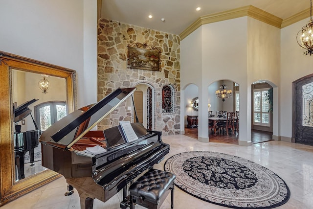 foyer featuring french doors, arched walkways, an inviting chandelier, and a towering ceiling