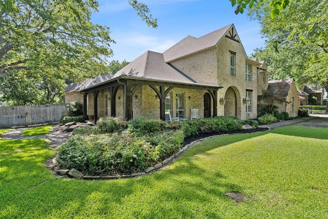 view of front facade with a front lawn, fence, and brick siding