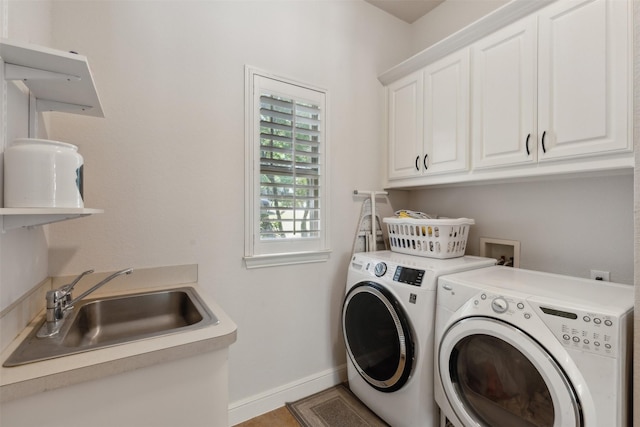 laundry room with a sink, baseboards, cabinet space, and washer and clothes dryer