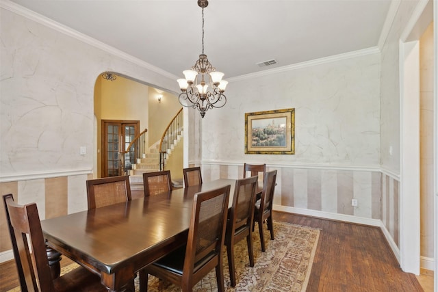 dining space featuring stairway, wood finished floors, visible vents, arched walkways, and crown molding