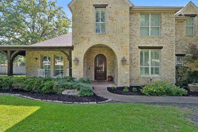 view of front of property with a front lawn, brick siding, and roof with shingles