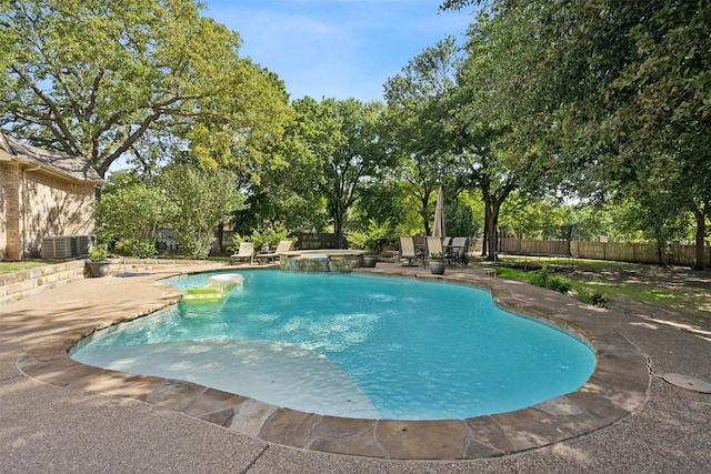 view of swimming pool with a patio, cooling unit, fence, and a pool with connected hot tub