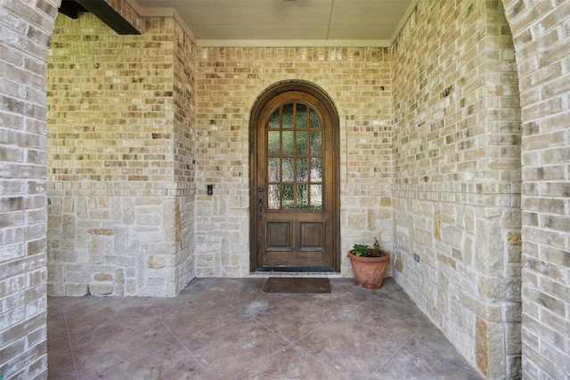 doorway to property with brick siding and stone siding