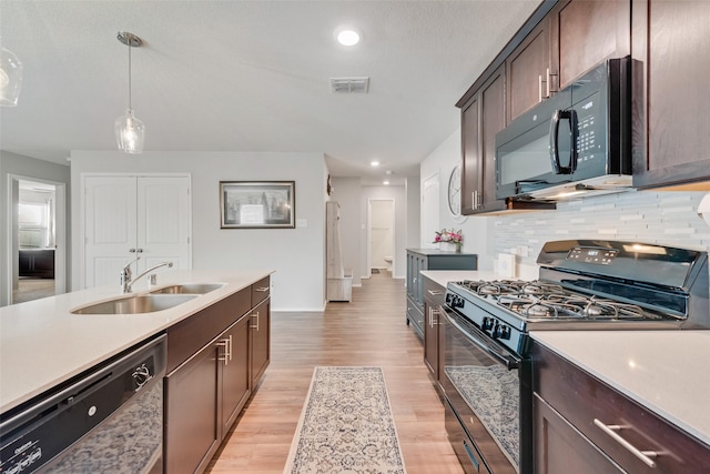 kitchen featuring a sink, visible vents, black appliances, and light countertops