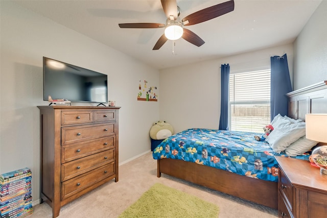 bedroom with a ceiling fan, baseboards, and light carpet