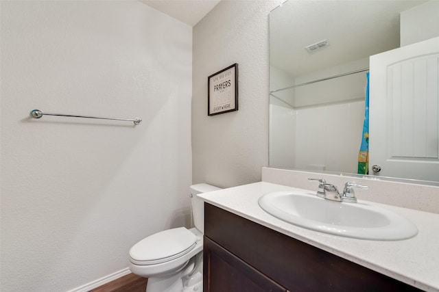 full bathroom featuring vanity, a shower with curtain, wood finished floors, visible vents, and toilet