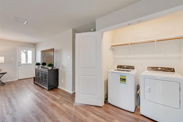 laundry area with laundry area, visible vents, light wood-style floors, and separate washer and dryer