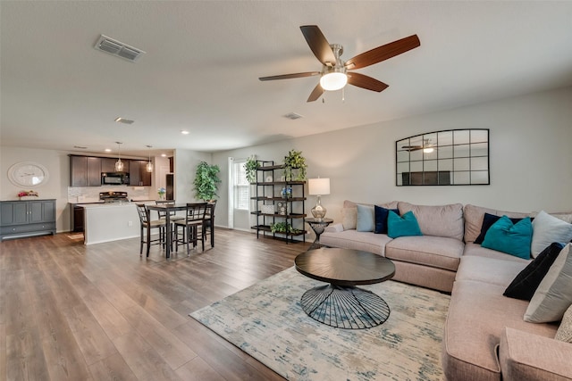 living area featuring recessed lighting, visible vents, dark wood-style floors, and a ceiling fan