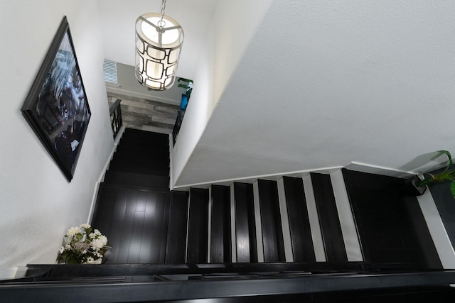 staircase with wood finished floors and baseboards