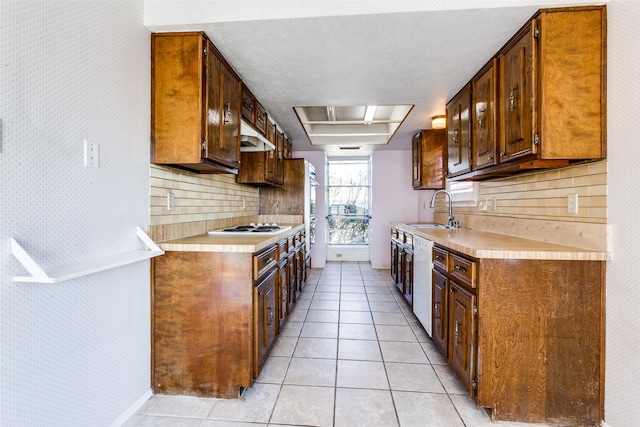 kitchen featuring a sink, white appliances, light tile patterned flooring, and light countertops