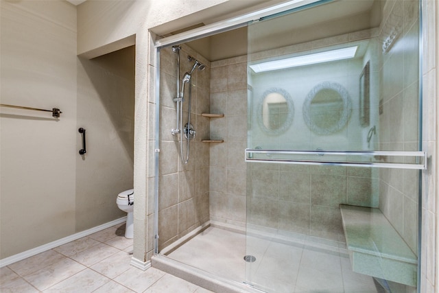 full bath featuring tile patterned floors, baseboards, toilet, and a shower stall