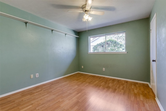 spare room featuring wood finished floors, baseboards, and ceiling fan