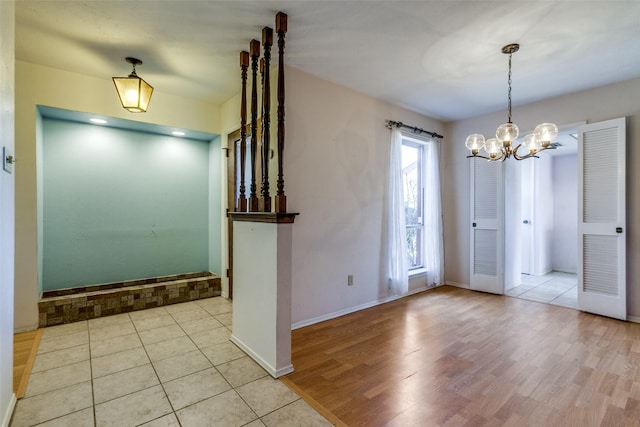 interior space featuring an inviting chandelier, baseboards, and light wood-style floors