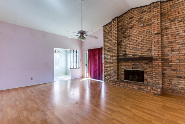 unfurnished living room featuring a brick fireplace, baseboards, wood finished floors, high vaulted ceiling, and a ceiling fan