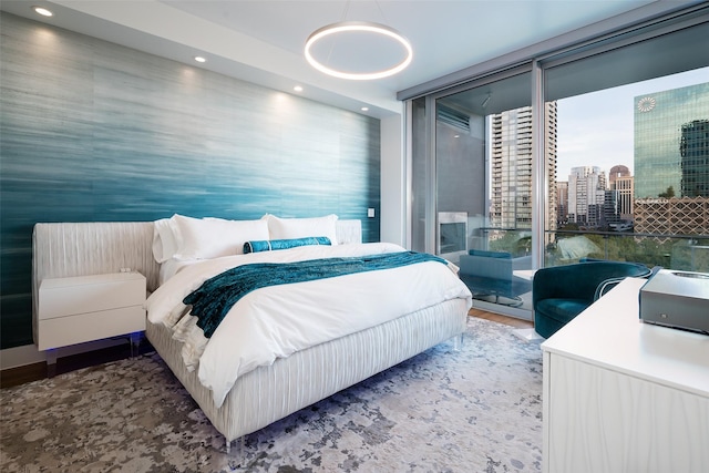 bedroom with floor to ceiling windows, wood finished floors, access to exterior, and recessed lighting