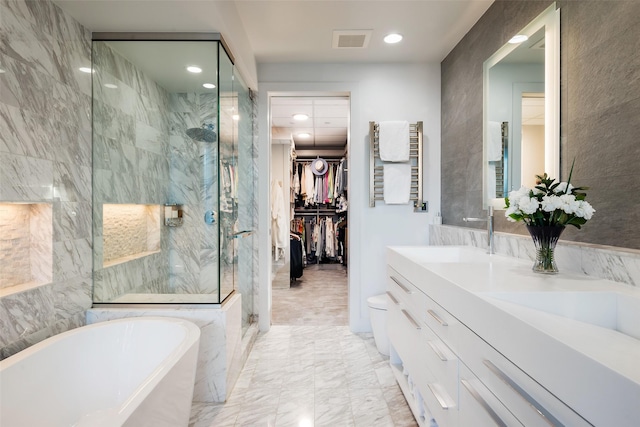 bathroom featuring recessed lighting, a freestanding bath, visible vents, vanity, and a marble finish shower