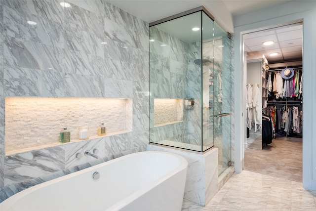 bathroom featuring a soaking tub, a marble finish shower, a spacious closet, recessed lighting, and marble finish floor