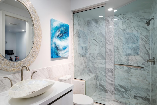 bathroom featuring a shower stall, toilet, vanity, and tile walls