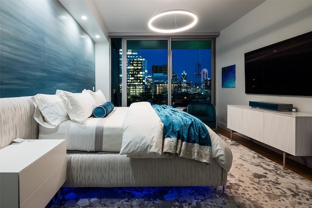 bedroom with baseboards, wood finished floors, and floor to ceiling windows