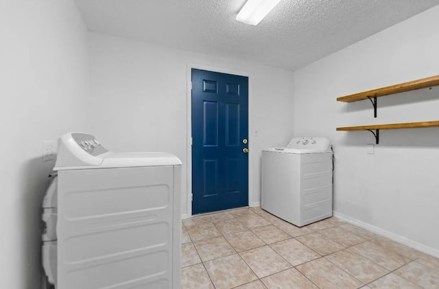 washroom featuring light tile patterned floors, laundry area, independent washer and dryer, and a textured ceiling