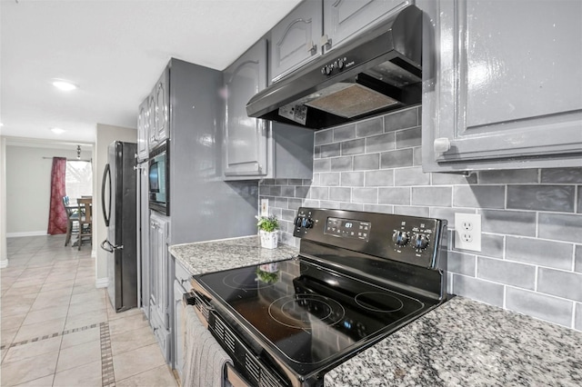 kitchen with gray cabinets, under cabinet range hood, stainless steel appliances, decorative backsplash, and light stone countertops