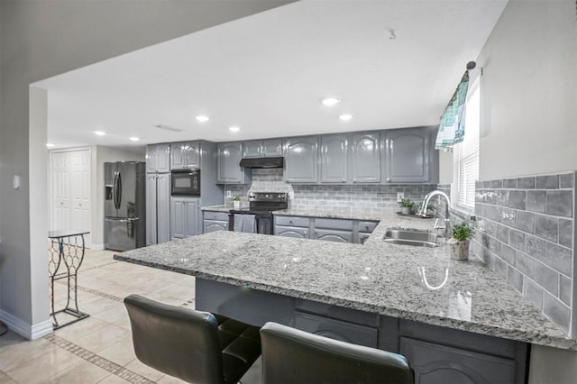 kitchen featuring black appliances, gray cabinets, a sink, a peninsula, and baseboards