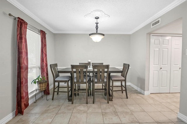 tiled dining room featuring crown molding, baseboards, visible vents, and a textured ceiling