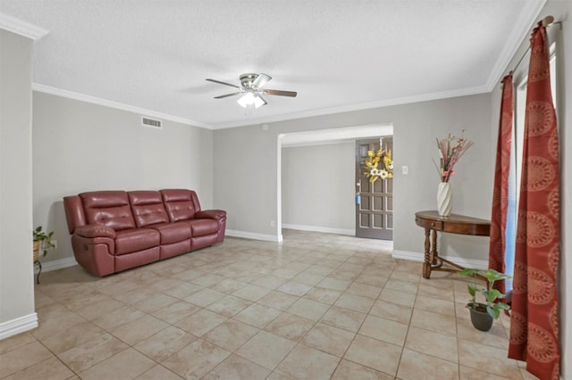 living area with visible vents, a textured ceiling, baseboards, and ornamental molding