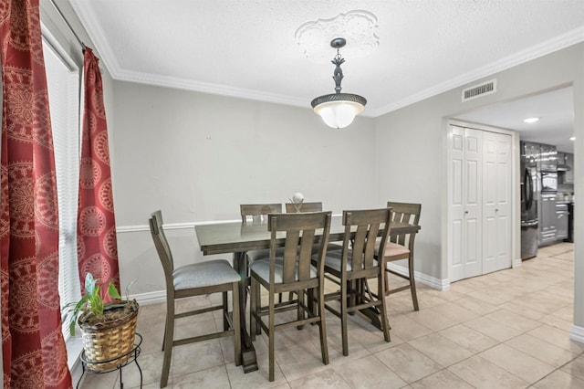 dining area with visible vents, ornamental molding, a textured ceiling, tile patterned flooring, and baseboards