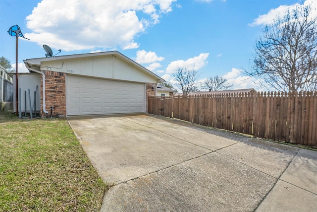 view of property exterior with fence, driveway, an attached garage, a yard, and brick siding