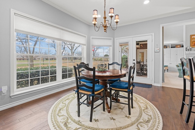 dining room featuring crown molding, baseboards, french doors, wood finished floors, and a notable chandelier