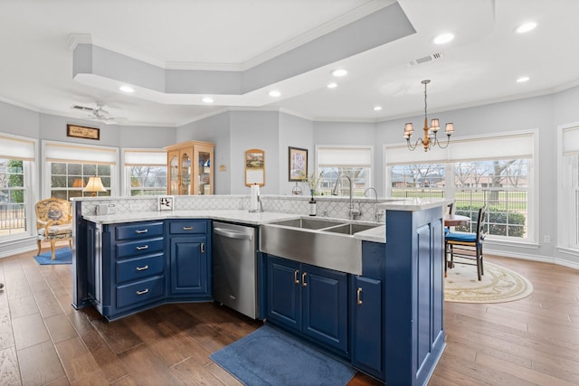 kitchen with dark wood finished floors, a sink, dishwasher, blue cabinets, and tasteful backsplash