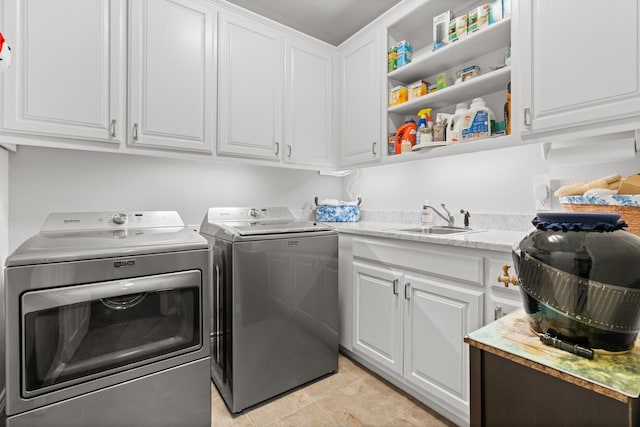 washroom with a sink, cabinet space, and separate washer and dryer