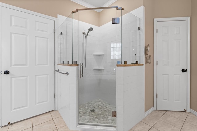 full bath featuring tile patterned floors, baseboards, and a shower stall