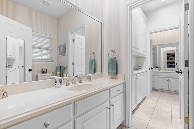 bathroom featuring tile patterned floors, visible vents, wallpapered walls, and vanity