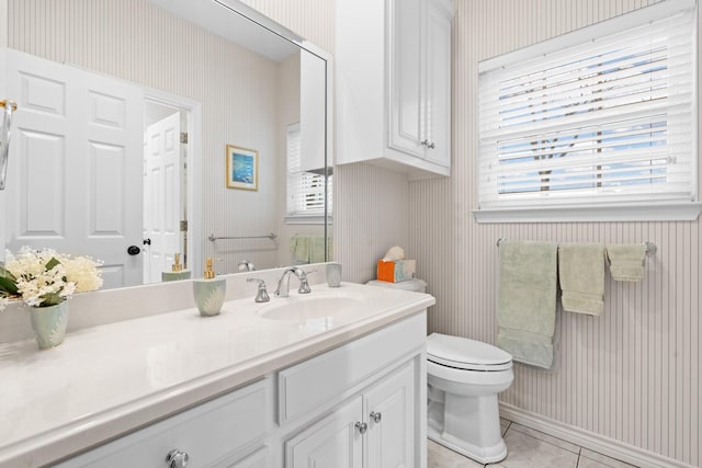 half bathroom with tile patterned flooring, toilet, wallpapered walls, and vanity