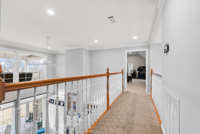 hall with visible vents, carpet floors, and ornamental molding