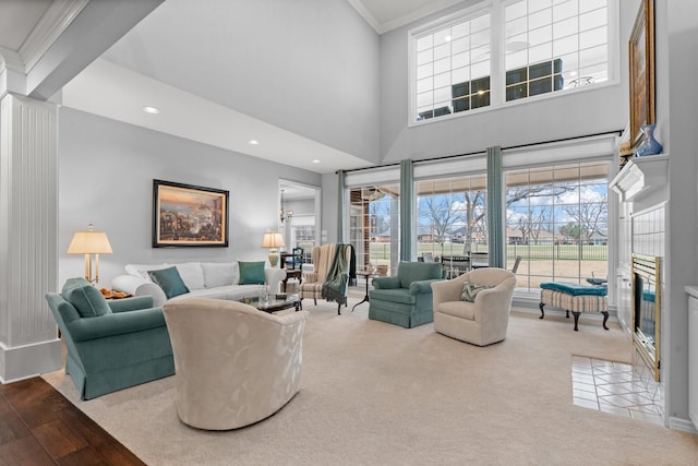 carpeted living area featuring recessed lighting, a towering ceiling, crown molding, and a sunroom