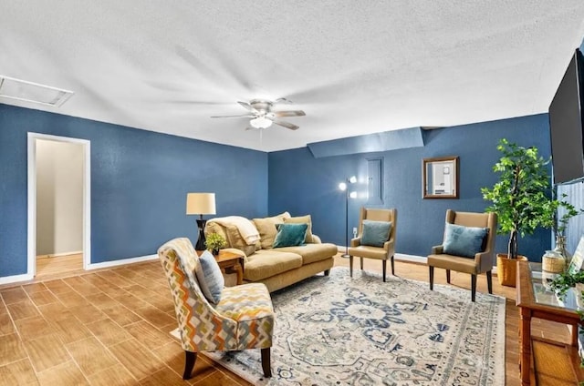 living area with attic access, baseboards, and a textured ceiling