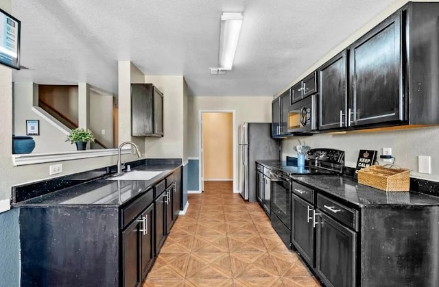 kitchen with dark cabinetry, dark stone countertops, a sink, black appliances, and a textured ceiling