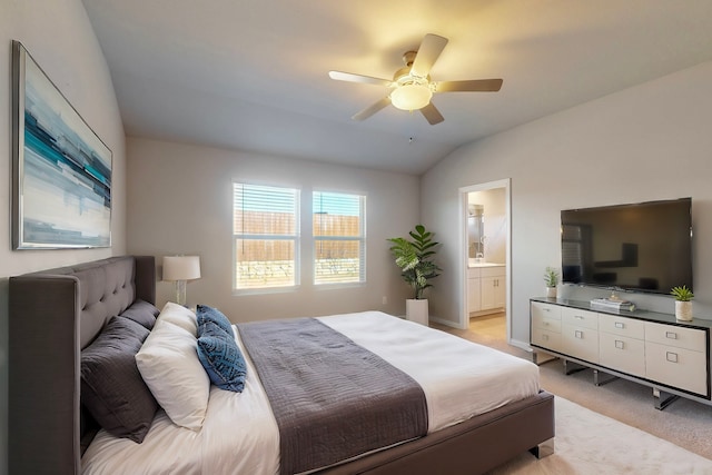 bedroom featuring ceiling fan, light colored carpet, ensuite bath, and vaulted ceiling