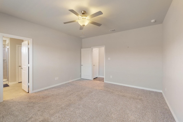 interior space featuring visible vents, light colored carpet, a ceiling fan, and baseboards