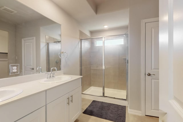 bathroom featuring a sink, visible vents, double vanity, and a shower stall