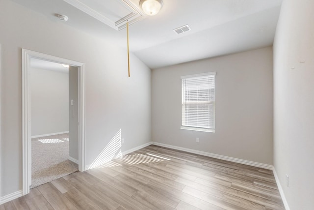 unfurnished room with visible vents, baseboards, attic access, and light wood-style flooring