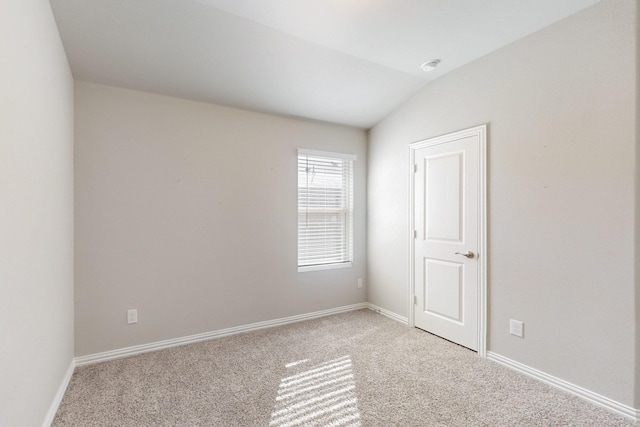 unfurnished room featuring light colored carpet, baseboards, and vaulted ceiling